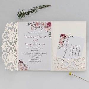 Dettaglio dell'invito di nozze intagliato al laser con custodia color crema e fiori eleganti