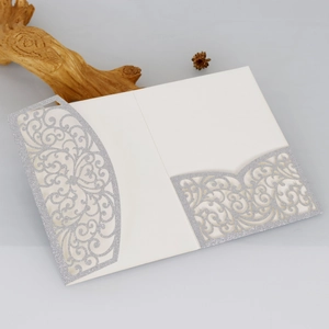 Détail d'invitation argentée découpée au laser avec motifs floraux sur fond décoratif