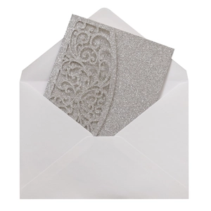 Détail de l'invitation argentée scintillante avec motifs floraux découpés au laser et enveloppe