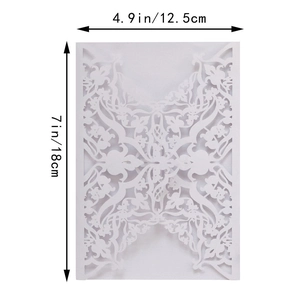 Detail of laser-cut floral pattern and lace texture on a white wedding invitation cover