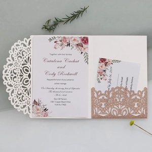Detail of laser-cut wedding invitation with floral insert and rose gold glitter pocket