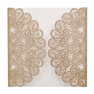 Detail of champagne gold glitter laser-cut wedding invitation with intricate lace patterns