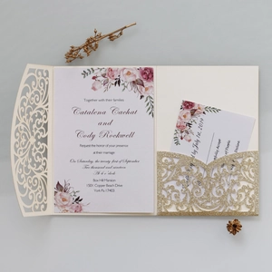Détail d'une invitation de mariage découpée au laser avec pochette dorée et carte RSVP