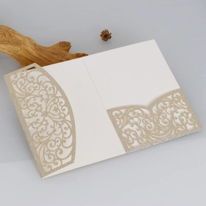 Vue macro d'une invitation de mariage dorée pailletée avec motifs floraux découpés au laser