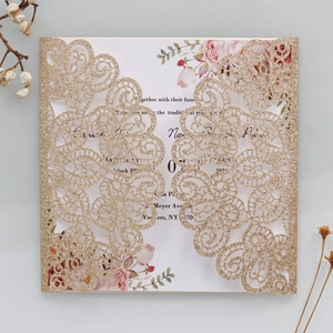 Detail view of laser-cut glitter gold peacock lace wedding invitation with floral insert card
