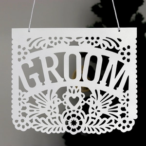 European style white paper banner featuring GROOM cutout text and floral patterns