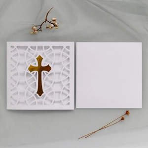 Detailed laser cut white card featuring a golden foil cross on elegant geometric patterns
