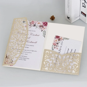 Détail de l'invitation de mariage dorée pailletée découpée au laser avec décor fleuri