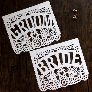 Detail of white laser-cut Groom and Bride wedding banners with elegant floral patterns