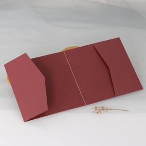 Detail of elegant dark red tri-fold pocket wedding invitation card with diagonal slots