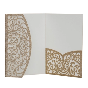 Détail de l'invitation dorée à paillettes avec motifs floraux découpés au laser