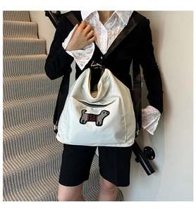 Detailed view of white nylon bag featuring cute dachshund embroidery and red-black stripes