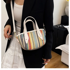 Détail du sac seau en paille tissée colorée avec poignées en cuir blanc et ferrures