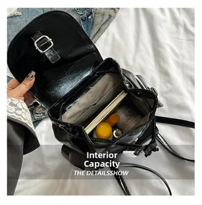 Vue intérieure du sac à dos en cuir verni noir montrant sa grande capacité et sa doublure
