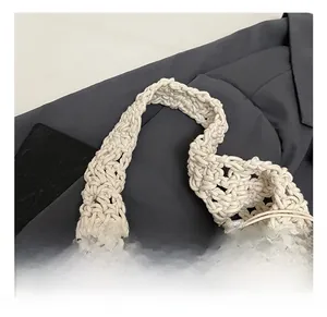 Detail des handgewebten Seilgriffs und der floralen Spitze an einer beigefarbenen Tasche