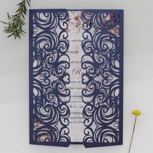 Detail of laser-cut midnight blue wedding invitation with elegant floral card insert