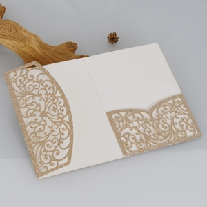 Gros plan d'une invitation découpée au laser en paillettes dorées avec détails ajourés
