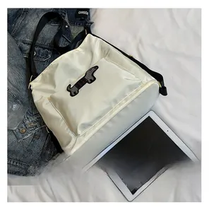 Detailed view of white nylon bag featuring sequined dachshund pattern and black strap
