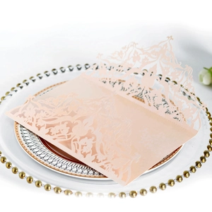 Detailed laser-cut floral pattern on a soft peach pink wedding invitation card