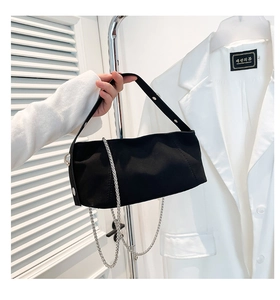 Detail of black fabric baguette bag featuring silver chain and metal hardware accents