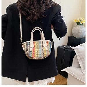 Détail du sac seau en paille tissée avec rayures rouges, jaunes et bleues et bandoulière