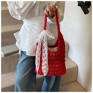 Detail of red crochet tote bag with white lace bow and beige drawstring inner lining