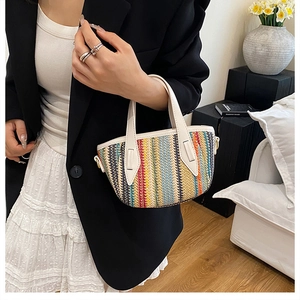 Détail d'un mini sac cabas tressé coloré avec des poignées en cuir blanc et décor