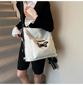 Detail view of a white nylon bucket backpack with a cute dachshund puppy pocket design