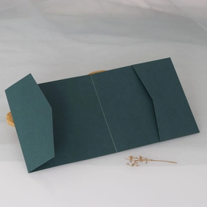 Detail of dark green tri-fold wedding invitation card cover with fine paper texture