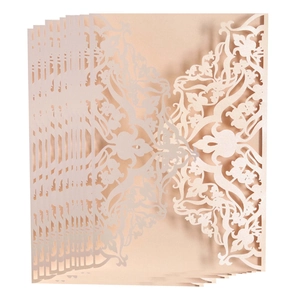 Macro detail of laser-cut hollow floral patterns on champagne gold wedding invitations