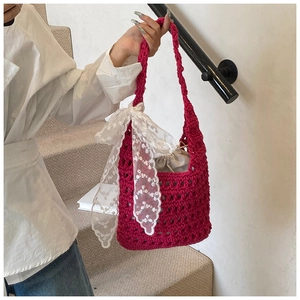 Detail of hand-woven magenta bucket bag with lace bow and drawstring cotton lining