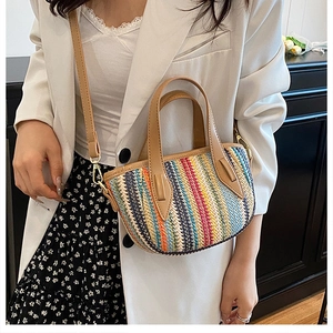 Détail du sac seau tissé à rayures colorées avec anse en cuir et boucles dorées