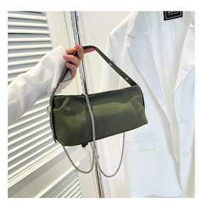 Detailed macro view of dark green suede texture handbag with silver chain strap