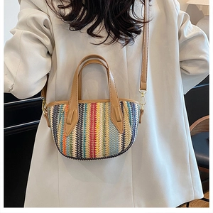 Détail du sac seau tissé à rayures colorées avec anses en cuir marron et attaches dorées