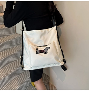 Detail view of large white canvas crossbody bag featuring cute dachshund embroidery patch