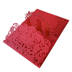 Close-up of 3D laser-cut wedding popup card with red floral arch and couple silhouette
