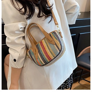 Détail du sac seau tissé à rayures colorées avec poignée en cuir marron et boucles dorées