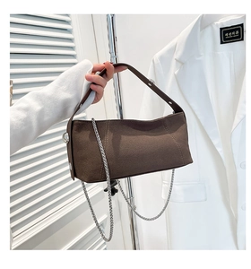 Detailed view of dark coffee suede handbag with metal chain and wide shoulder strap