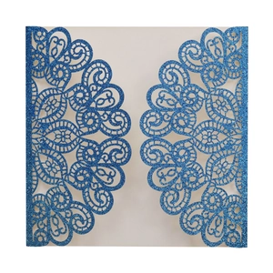 Detail of laser-cut royal blue glitter invitation with intricate mandala floral patterns