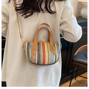 Détail du sac seau tissé coloré avec bandoulière en cuir marron et boucles dorées
