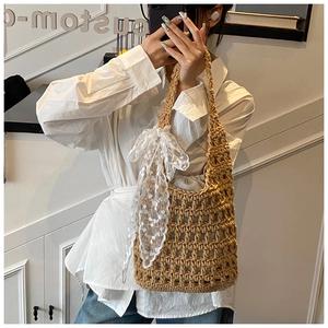 Detail of hand-woven crochet bucket bag with a white lace bow and gray fabric lining