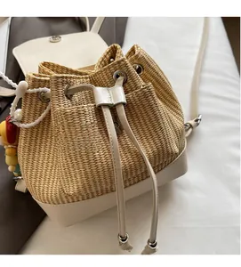 Detail eines Stroh-Eimerrucksacks mit beigem Lederbesatz und Kordelzugverschluss