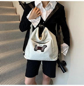 Close-up of white nylon crossbody bag with cute dog patch and black adjustable strap