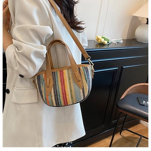 Sac seau à rayures colorées sur mannequin en blanc, avec bandoulière marron et boucles d'or