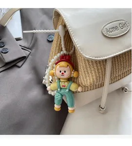 Nahaufnahme eines niedlichen Comic-Anhängers mit Perlenkette an einem gewebten Rucksack
