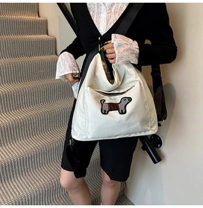 Detailed close-up of a white cartoon dog embroidery on a nylon crossbody shoulder bag