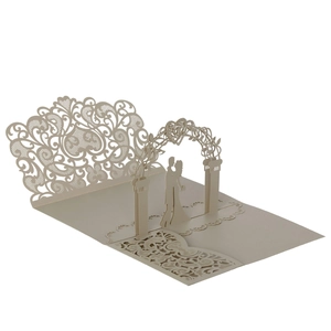 Detail view of 3D laser-cut wedding card featuring a romantic couple under floral archway