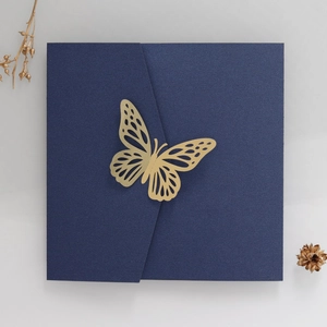 Detail view of dark green wedding invitation with a golden laser-cut butterfly seal