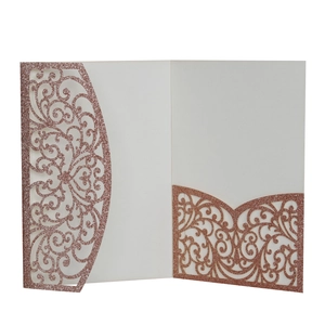 Détail macro de l'invitation de mariage pailletée or rose avec pochette découpée