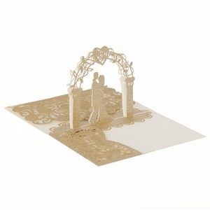 Macro detail of laser-cut 3D wedding card with gold glitter paper and couple silhouette